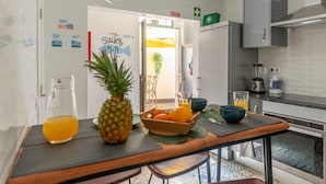 Una cocina moderna con una mesa de madera mostrando frutas y una jarra de vidrio.