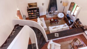 A spacious living area with a fireplace, a bookshelf, and a comfortable seating arrangement. - Villa La Fenice by Wonderful Italy (Castellammare del Golfo)
