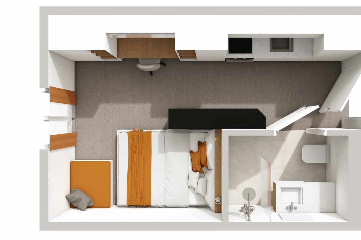 A modern hotel room with a bed, a desk, a bathroom, and a small sitting area.