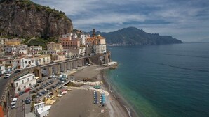 Eine Küstenstadt mit historischen Gebäuden, einem Strand und Meerblick.
