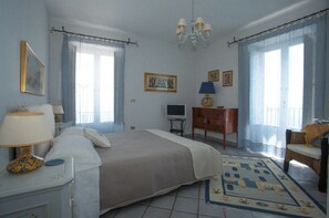 Une chambre à coucher avec un lit, une télévision, une commode et une chaise.