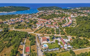 An aerial view of a coastal town with residential buildings, a marina, and a sports complex. - Apartments with Shared Pool Rocco 1 (Medulin)