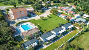 An aerial view of a residential area with multiple houses, a swimming pool, and green lawns. - Apartments with Shared Pool Rocco 1 (Medulin)