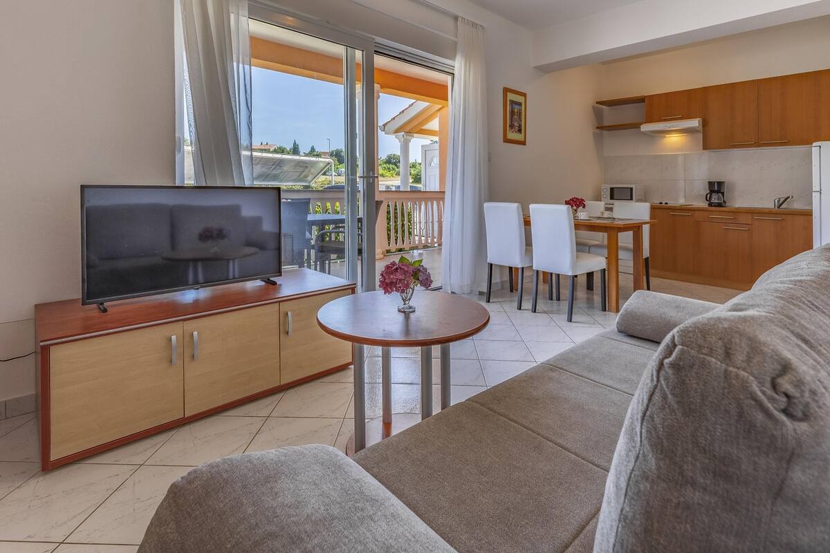 A modern apartment with a living room, dining area, and kitchen.