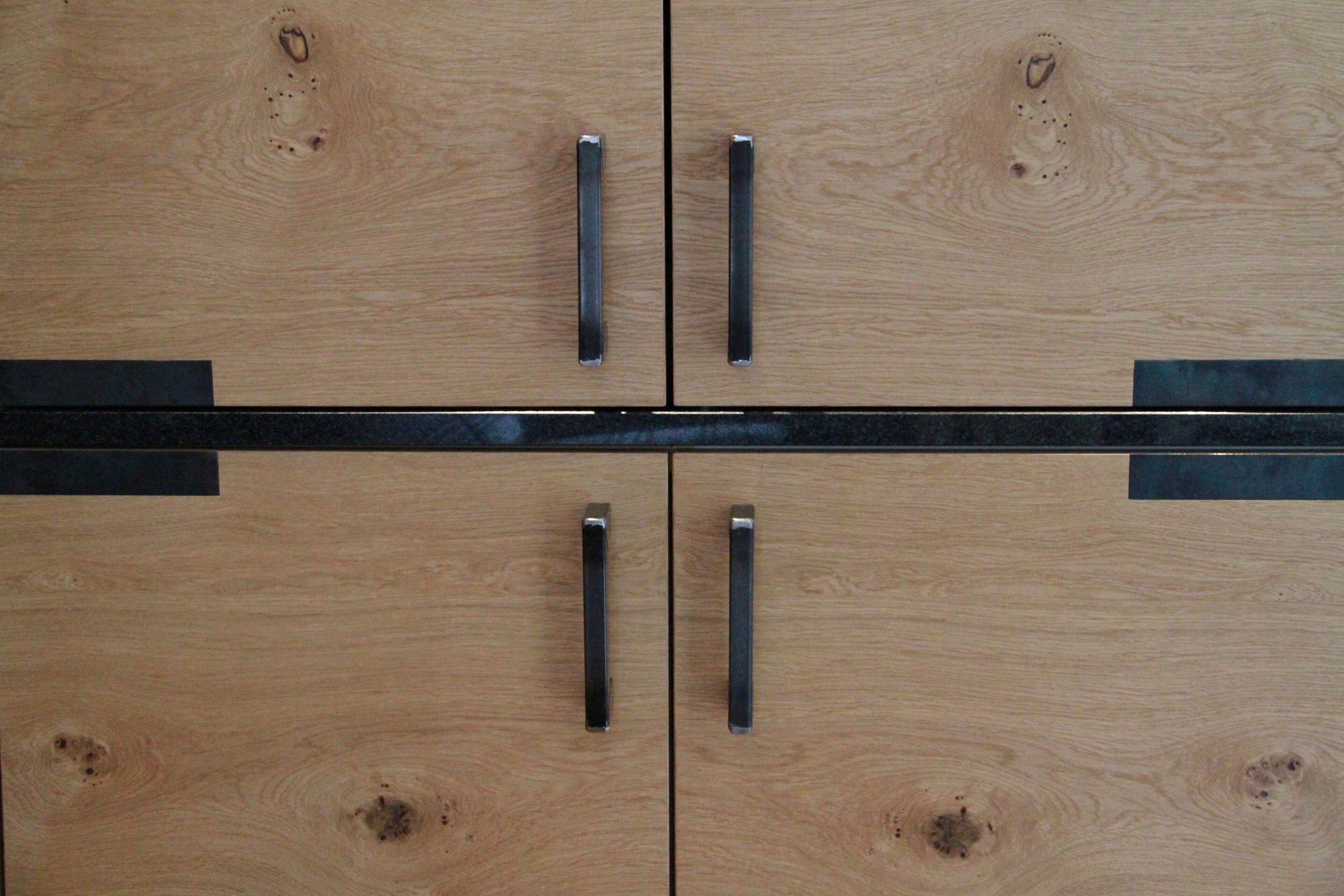 A wooden cabinet with four drawers and two metal handles.