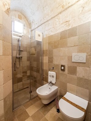 A bathroom with a glass-enclosed shower, a toilet, and a bidet. - Masseria Scaledda (Manduria)