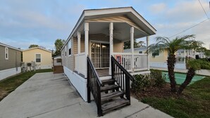 A single-story house with a porch, a staircase, and a small front yard. -  1-Bedroom House  5 Star in Disney Area  Mill Creek Resort 2732 (Kissimmee)