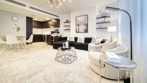 Una sala de estar moderna con comedor, cocina y un amplio ventanal con cortinas.