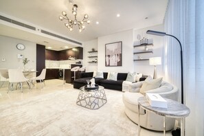 Una sala de estar moderna con comedor, cocina y un amplio ventanal con cortinas.