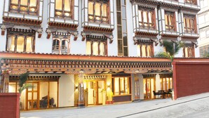 A traditional multi-story building with ornate windows and a covered entrance. - Hotel Mayto (Thimphu)