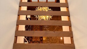 A wooden staircase with a view of a room below. - Hotel Mayto (Thimphu)