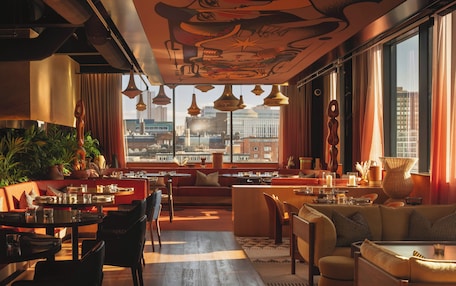 A modern interior with a city view, dining area, and seating arrangements.