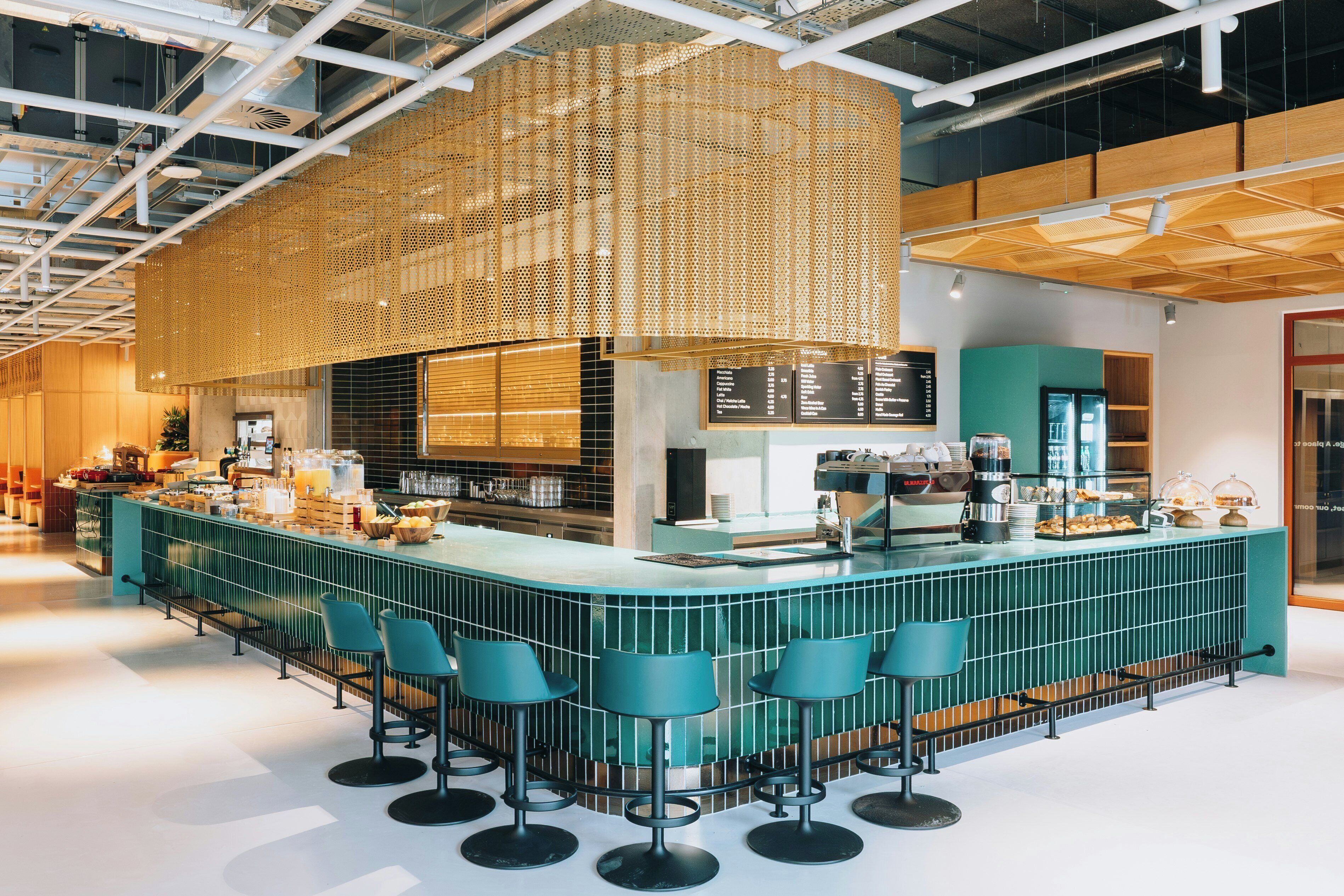A bar area with a counter, stools, and a menu board.