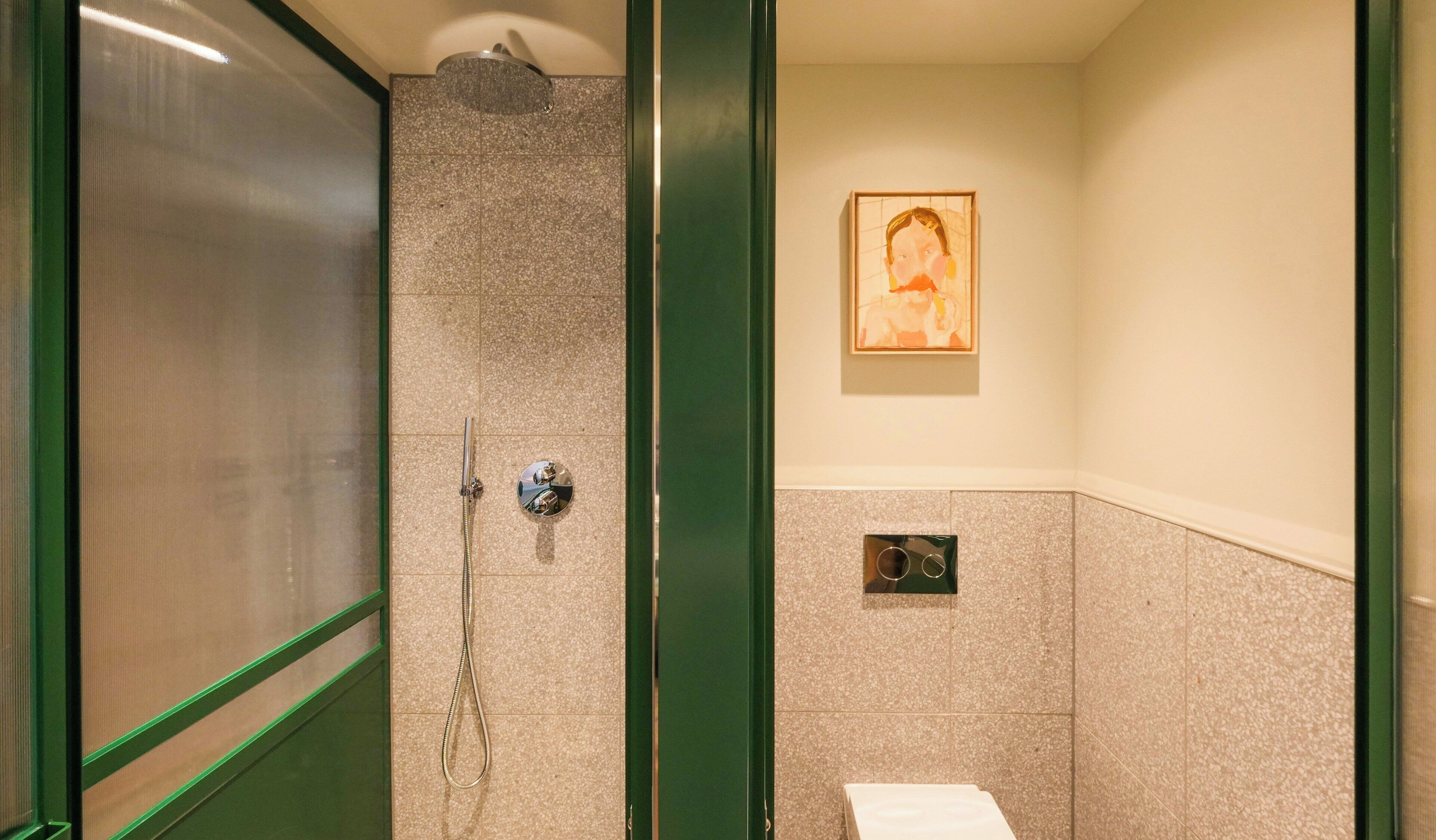 A bathroom with a shower, a toilet, and a towel rack.