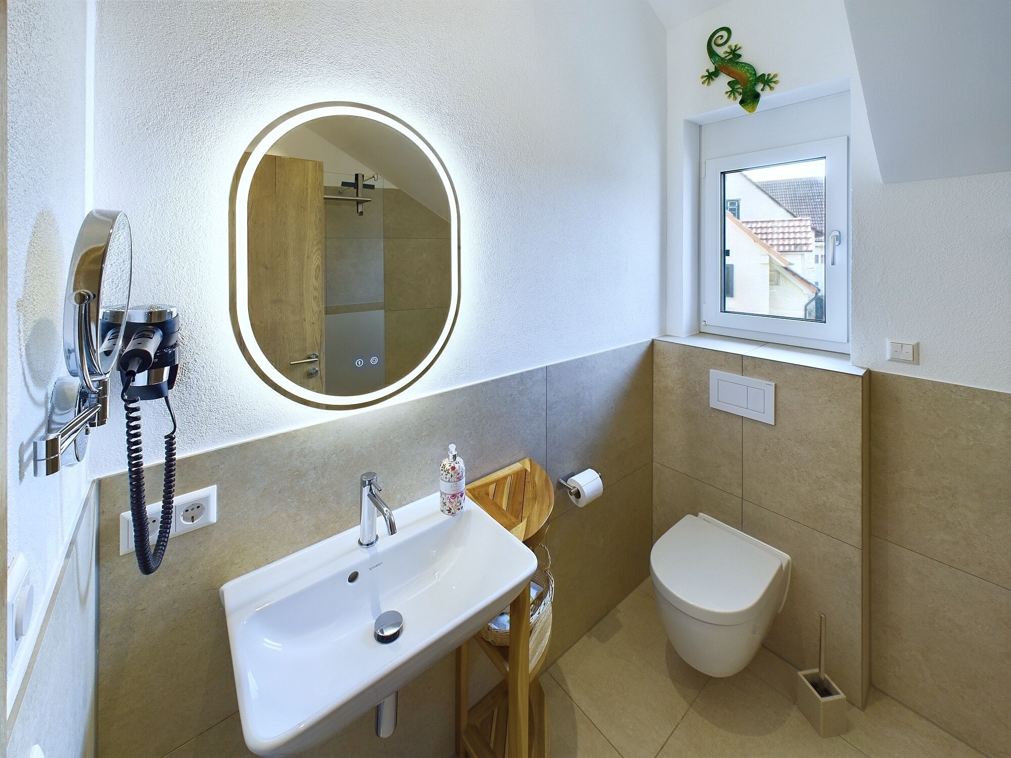 Un baño con un lavabo blanco, un espejo, un inodoro y una ducha.