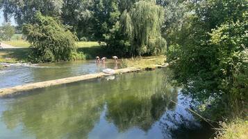 Une rivière paisible, bordée d’un étroit sentier en béton pour se promener.