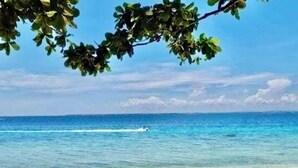 A beach with clear blue water and a sandy shore. - Condo by the Beach OMP Mactan Int'l Airport, 2 bedrooms/2 baths sleeps 7 guests (Lapu-Lapu City)