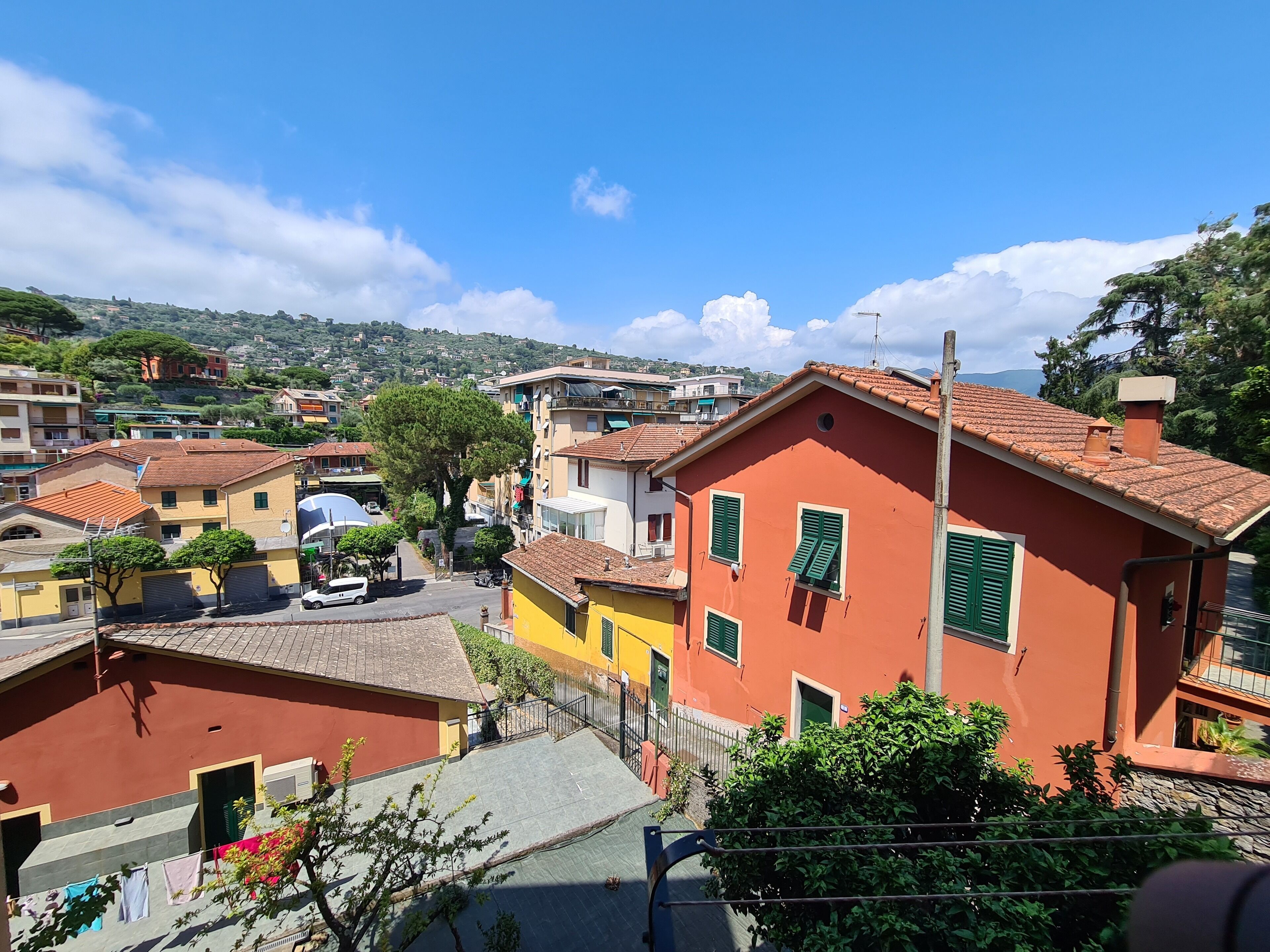 A residential area with colorful buildings, a clear sky, and a distant mountain range.