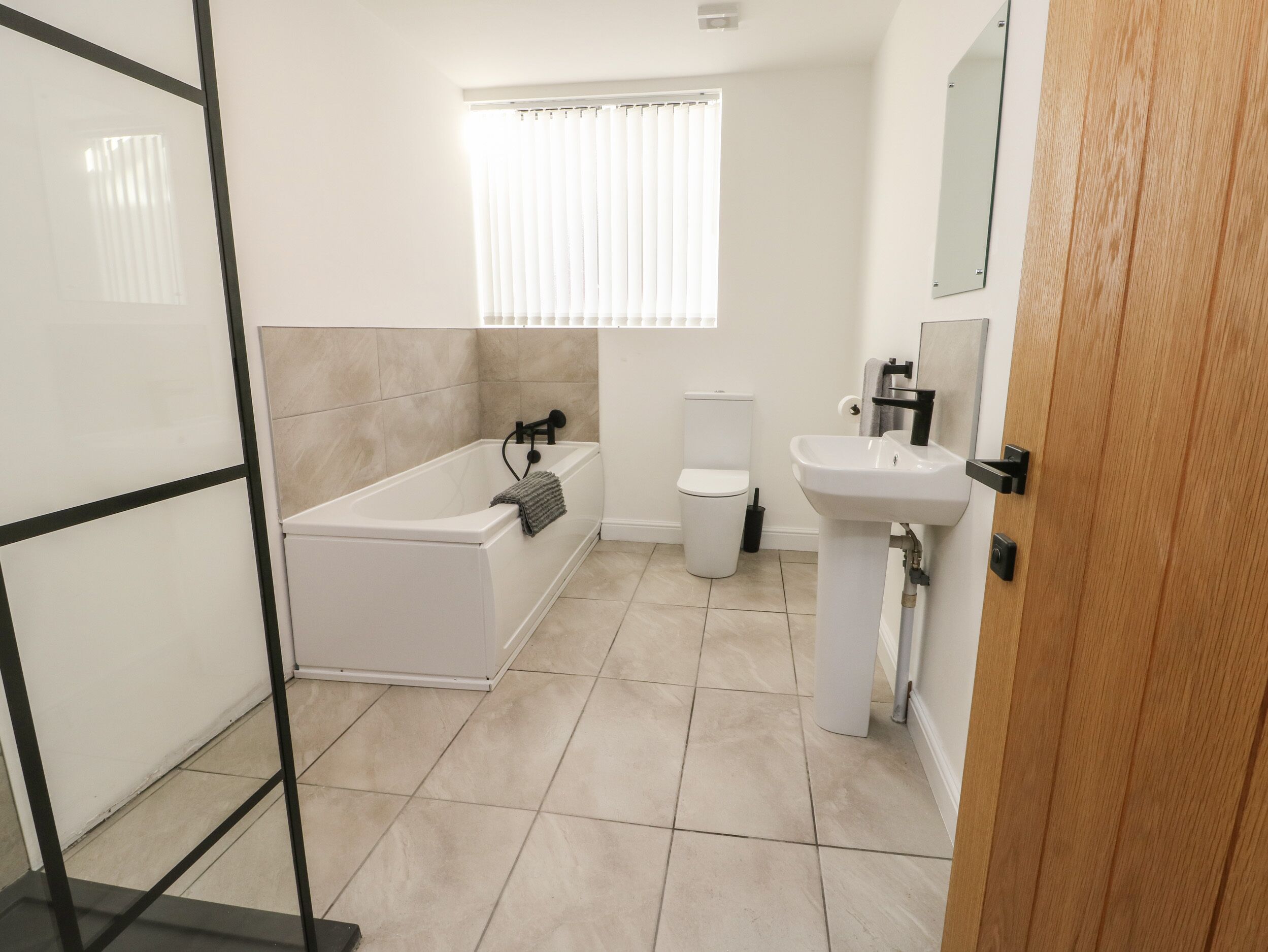 Une salle de bain moderne équipée d’une baignoire, de toilettes et d’un lavabo.