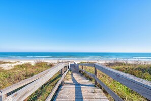 A wooden boardwalk leading to a beach with clear skies. - Spacious, cozy condo in Mustang Island Beach Club! Beach access, community heate (Corpus Christi)