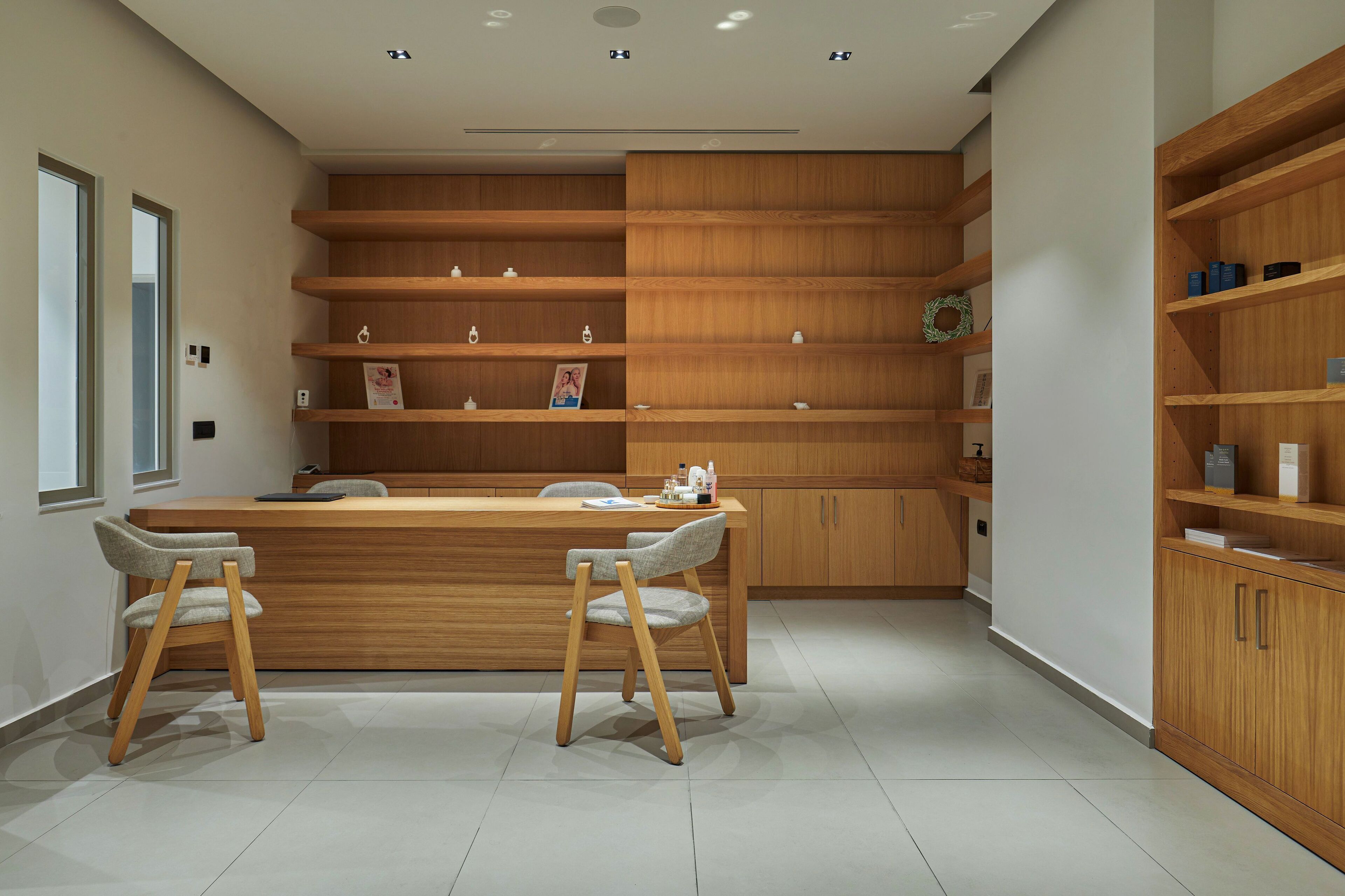 A modern kitchen with wooden cabinets, a central island with chairs, and a view of the adjacent room.