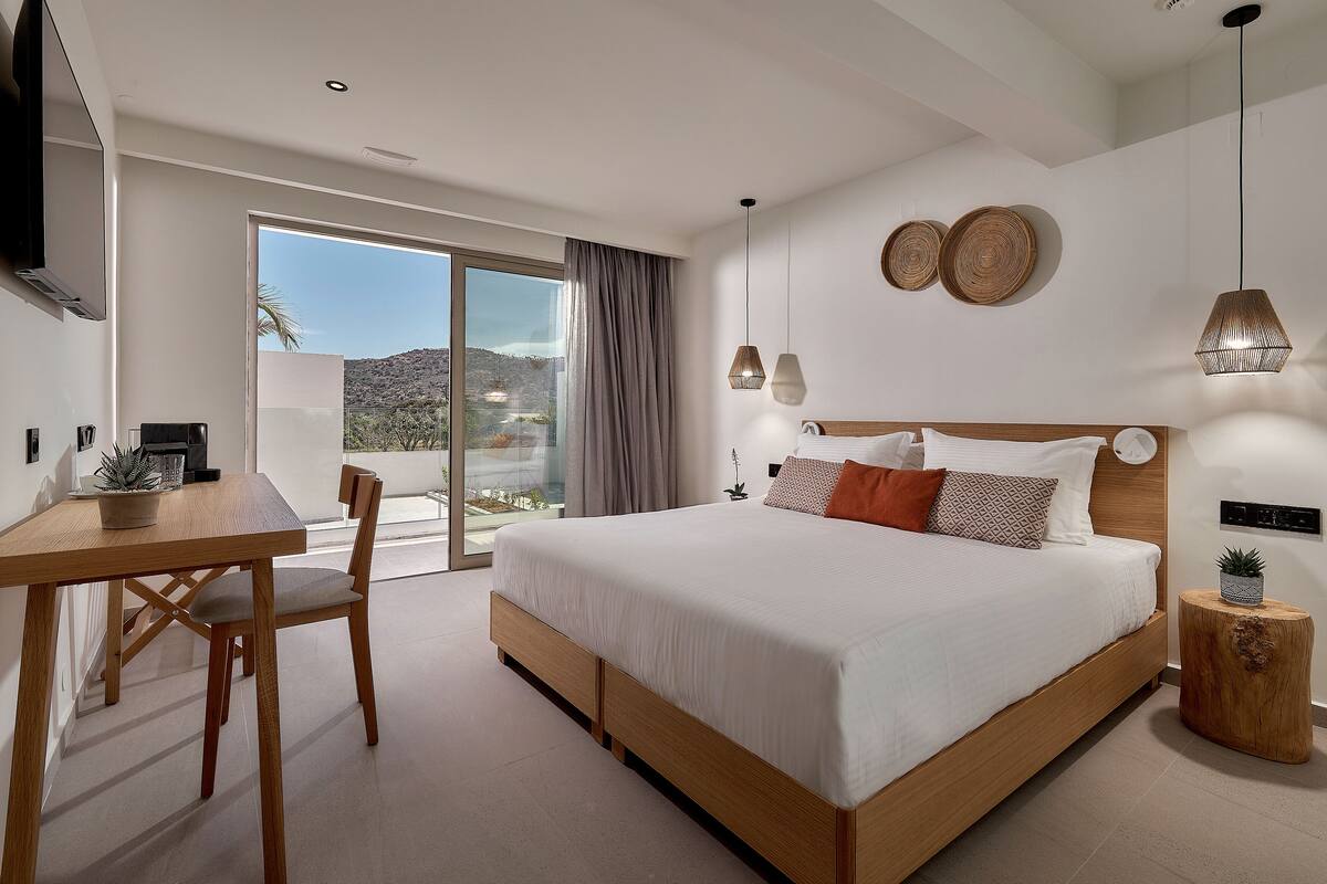 Een moderne slaapkamer met een groot bed, een eettafel en uitzicht op de omgeving.