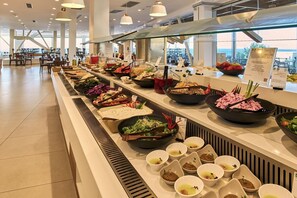 Un bufé con diversas opciones de comida, como ensaladas, sopas y otros platos.