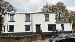 Un bâtiment à deux étages, doté d’une façade blanche et de bordures noires.
