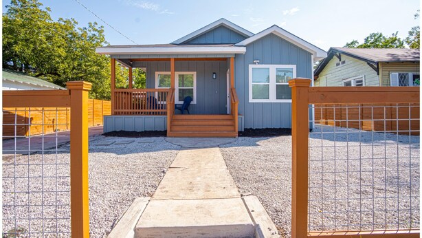 A single-story house with a front porch, a covered entryway, and a gravel driveway. - Spectacular Brand New 4br/2.5ba Near DT/ Riverwalk (San Antonio)