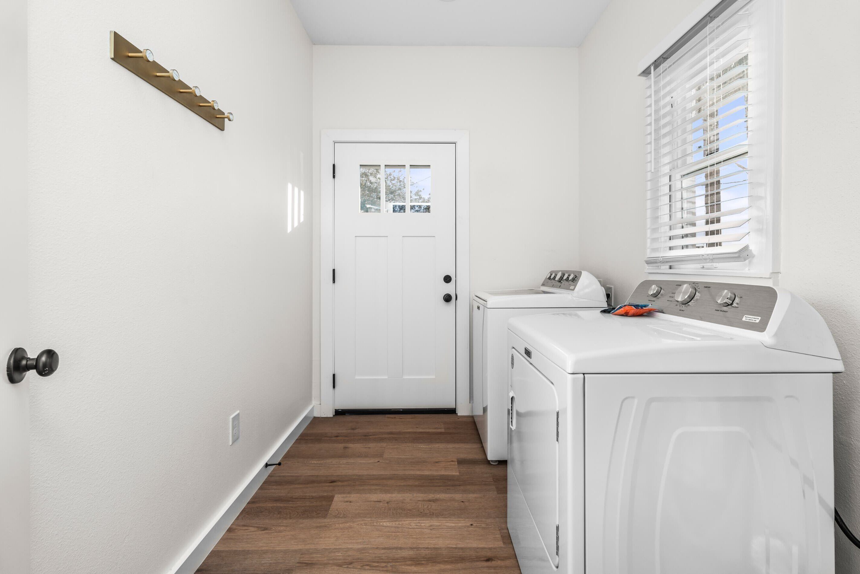A laundry room with a white door, a washing machine, and a dryer.