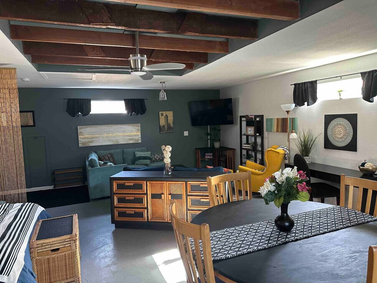 Een moderne woonruimte met een eethoek, een bank en een televisie.