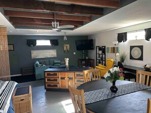 A modern living space with a dining area, a sofa, and a TV. - Simply Spacious Studio Guesthouse (Sacramento)