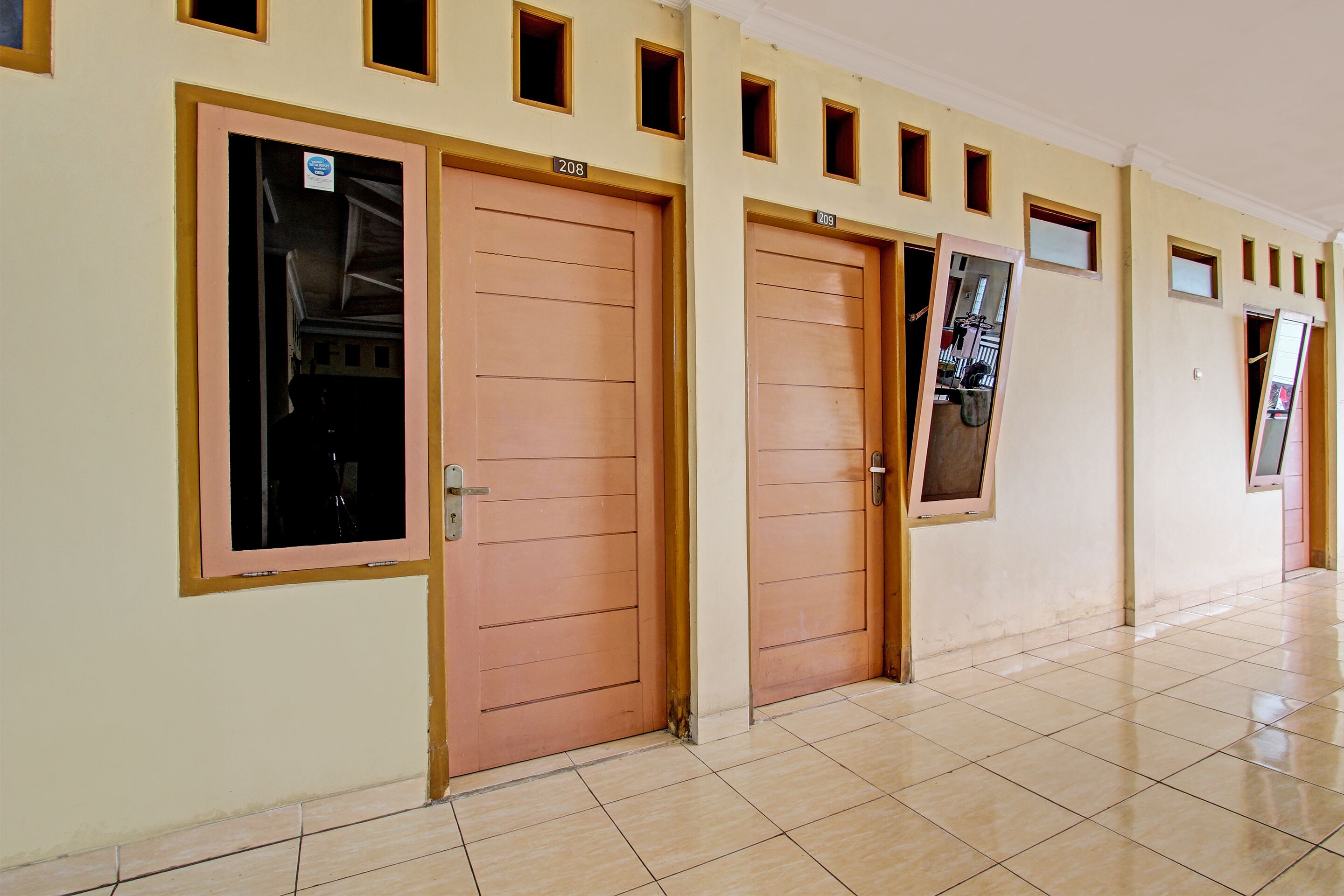 A hallway with doors numbered 208 and 209, each with a small window above the door.