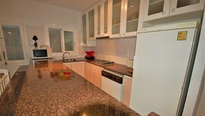 A kitchen with granite countertops, white cabinets, a microwave, a sink, and a dishwasher. - SAONA VILLAS (VN OLIVE): villa for 10 people, private swimming pool, air co (Les Tres Cales)