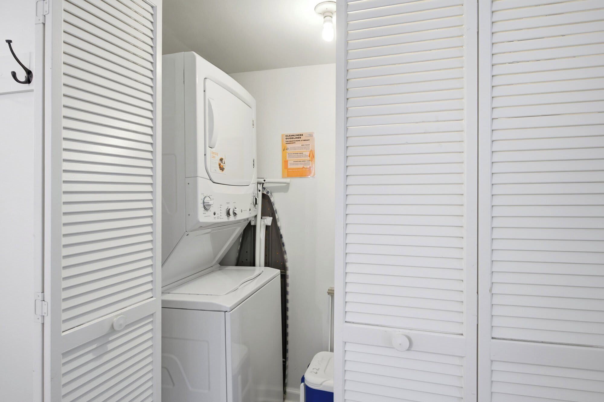 Une buanderie équipée d’un lave-linge, d’un sèche-linge et d’un évier utilitaire.