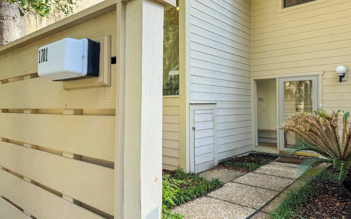 A house with a mailbox, a door, and a small garden with plants.
