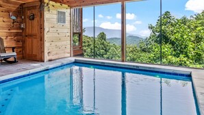 Eine Holzhütte mit Pool und Bergblick.
