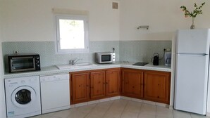 A compact kitchen with a washing machine, a microwave, a coffee maker, and a refrigerator. - Mini-villa No. 9 - 2/4 people (PORTO VECCHIO)