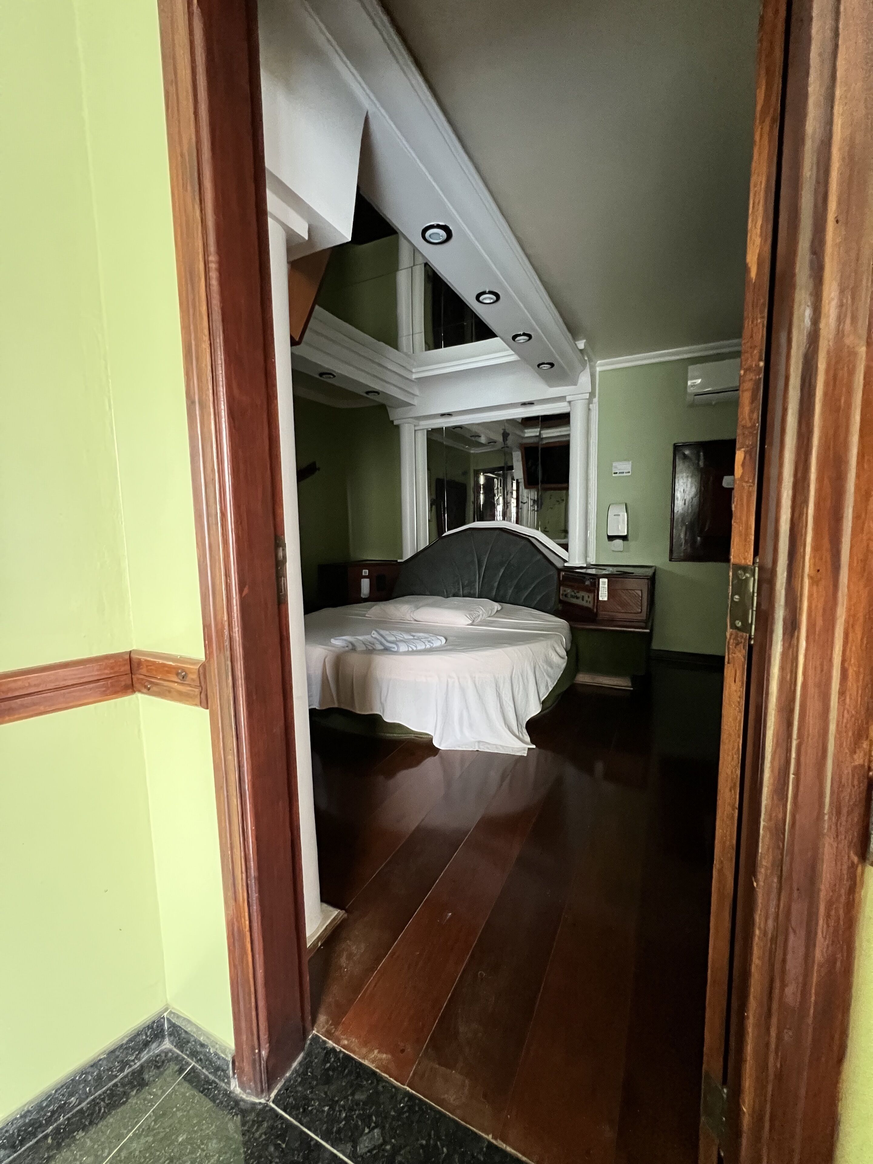 Een slaapkamer met een bed, nachtkastje en dressoir.