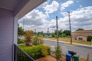 A residential area with a street, utility poles, and a building with a sign. - Bold 4BR/3.5BA PLUS Guesthouse w/ Downtown Views! (San Antonio)