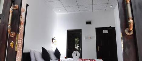 Una habitación de hotel con cama, puerta y techo con iluminación empotrada.