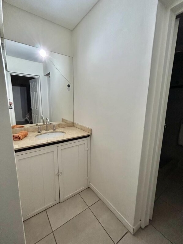 Un baño con lavabo, espejo y armarios.