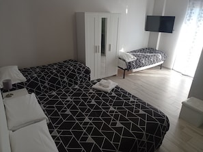 Chambre Quadruple Confort | Bureau, rideaux occultants, fer et planche Ă repasser, Wi-Fi gratuit