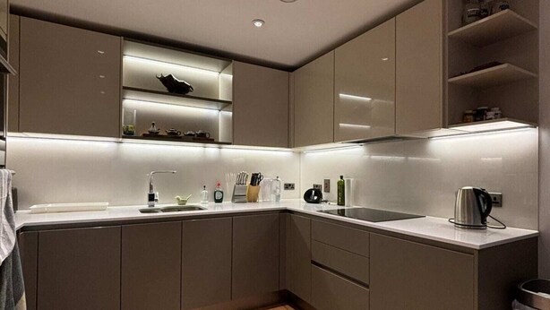 A modern kitchen with built-in cabinets, a countertop, and a wooden floor. - Stylish & Modern 1BD Flat - Chancery Lane! (London)