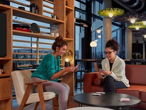 A modern interior with wooden shelves, a round table, and a seating area. - Aparthotel Adagio Heidelberg (Heidelberg)