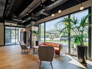 Un interior moderno con una zona de estar, ventanas amplias y vistas al exterior.
