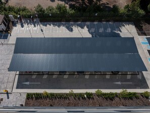 An aerial view of a parking lot with marked spaces and a large covered area. - Ibis Budget Madrid Aeropuerto (Madrid)