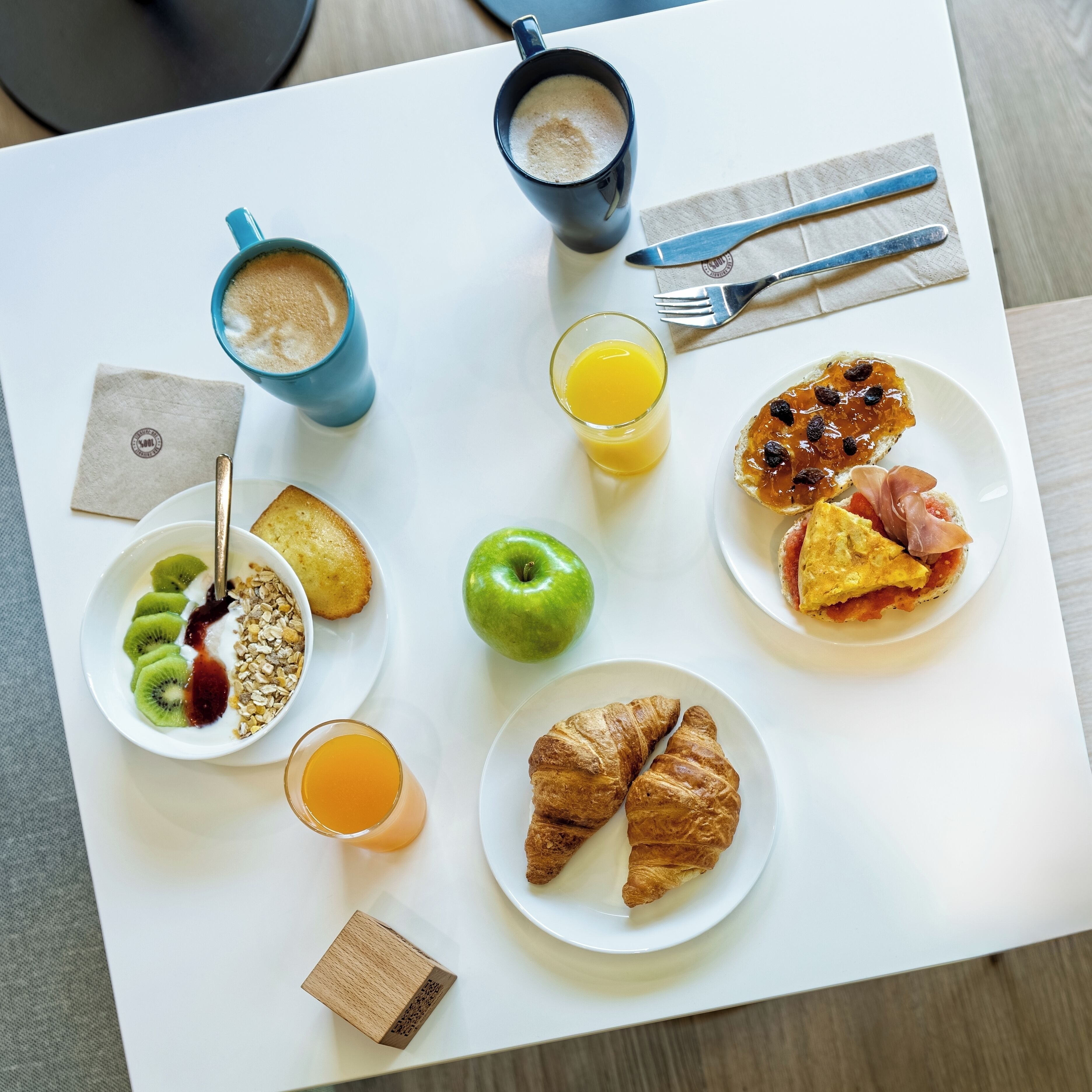 A breakfast table with various food items and drinks.