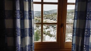 A window with a view of a snowy landscape and a road.