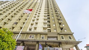 A high-rise building with multiple balconies and a flag. - OYO Life 92718 Apartement Gateway Cicadas (Bandung)